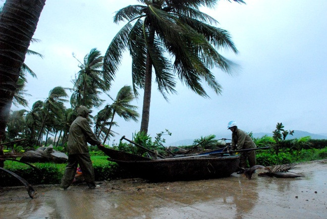 Người dân đi chuyển thuyền bè để tránh bão.