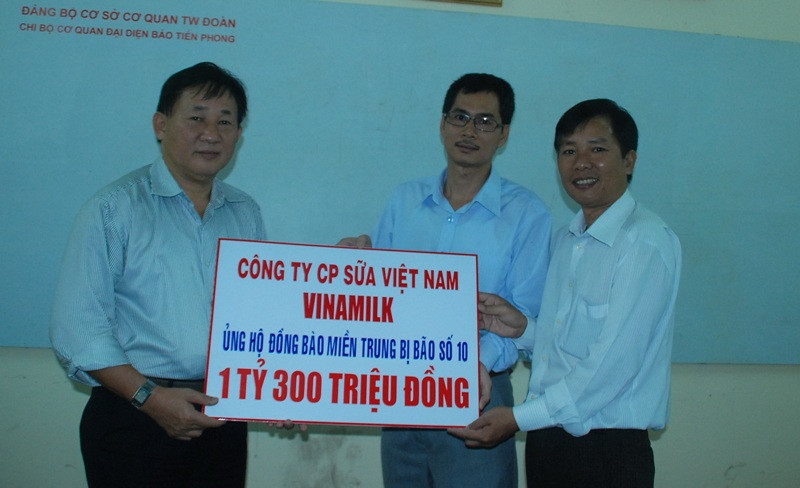 Ông Nguyễn Thanh Tú (trái) đại diện Công ty Vinamilk trao số tiền 1,3 tỷ đồng cho báo Tiền Phong