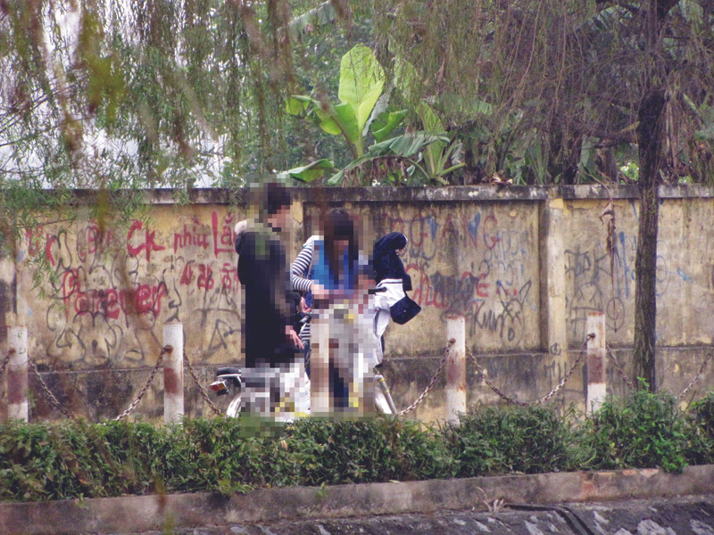 Ngồi tâm sự ở hồ Văn Quán đến sát giờ học, cô gái vội vàng lấy áo đồng phục, yêu cầu bạn trai chở về trường. Ảnh: Trường Phong