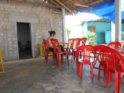 Một gái đang ngồi chờ khách trên bãi biển