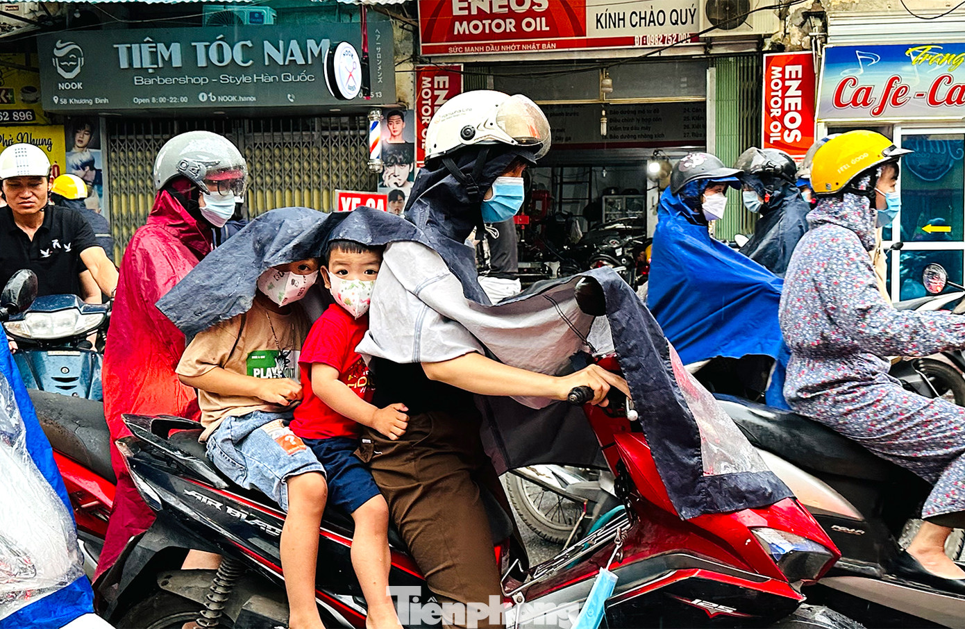 Nhiều phụ huynh chật vật trong cơn mưa khi đưa con đi học vào đầu giờ sáng.