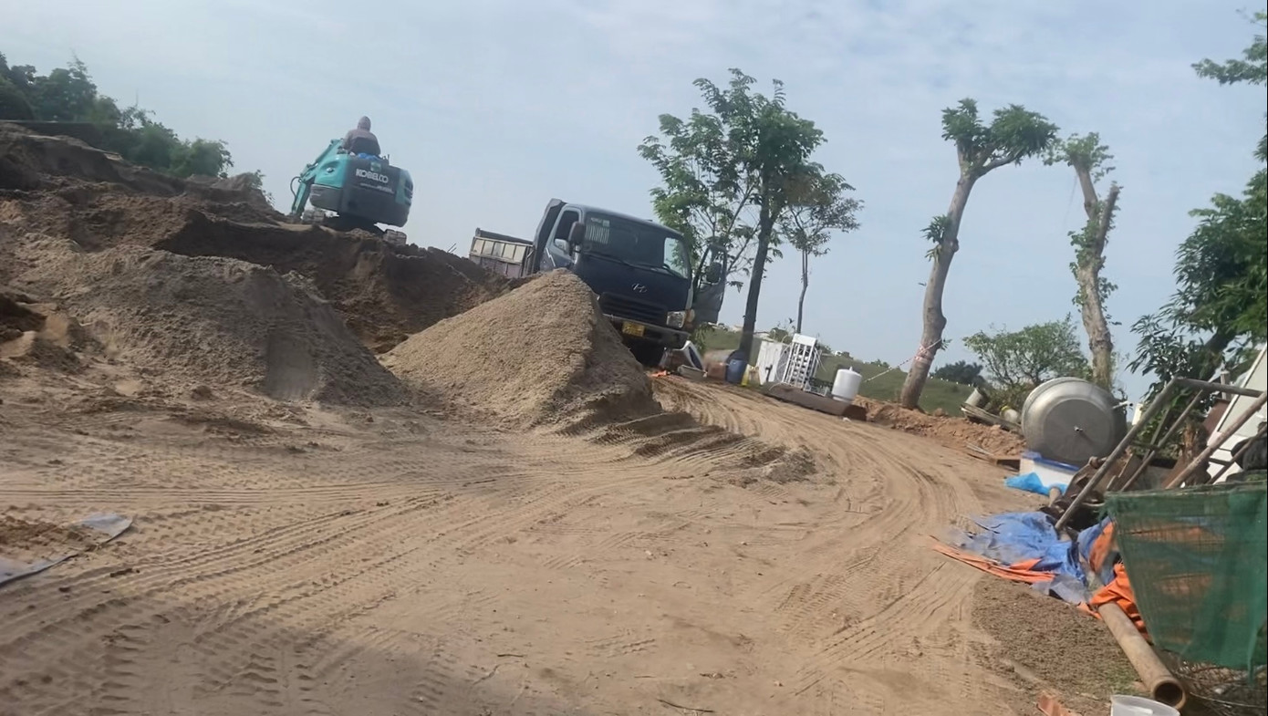 Bãi tập kết xây dựng có xe tải và cần cẩu đang hoạt động ở gần khu vực sạt lở, được phóng viên ghi nhận ngày 30/10.