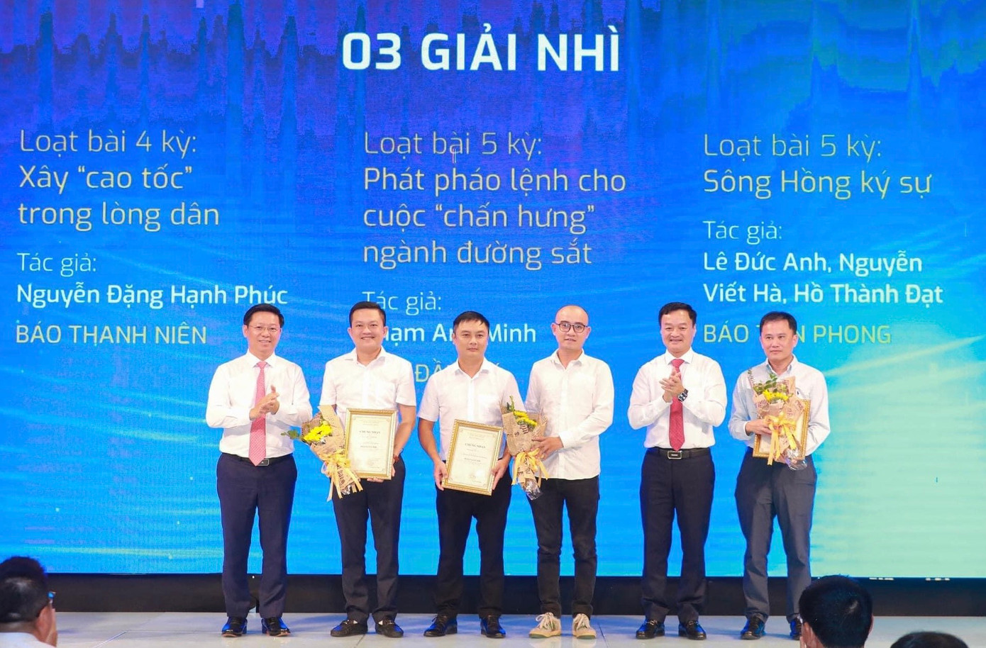 Hai nhà báo Nguyễn Viết Hà và Hồ Thành Đạt (thứ ba và thứ tư từ trái sang) đại diện nhóm tác giả của loạt bài &quot;Sông Hồng ký sự&quot; lên bục nhận giải Nhì từ ban tổ chức.
