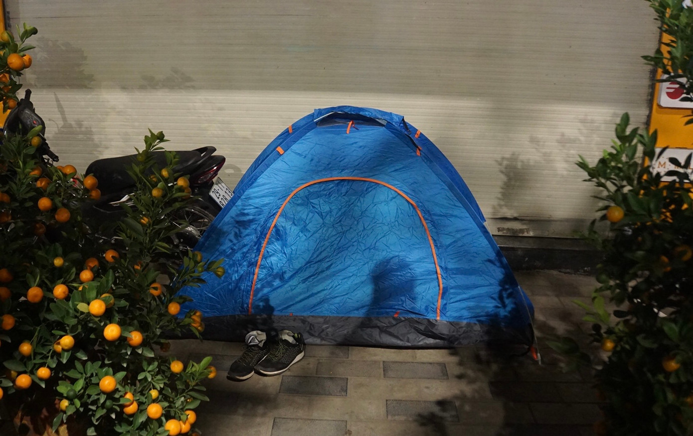 Chỗ ở của anh Nam trong những ngày này là chiếc lều cắm trại mua ngoài chợ, dựng tạm trên vỉa hè. Anh sẽ "tá túc" tại đây trong vài tuần trước khi về quê đón Tết.