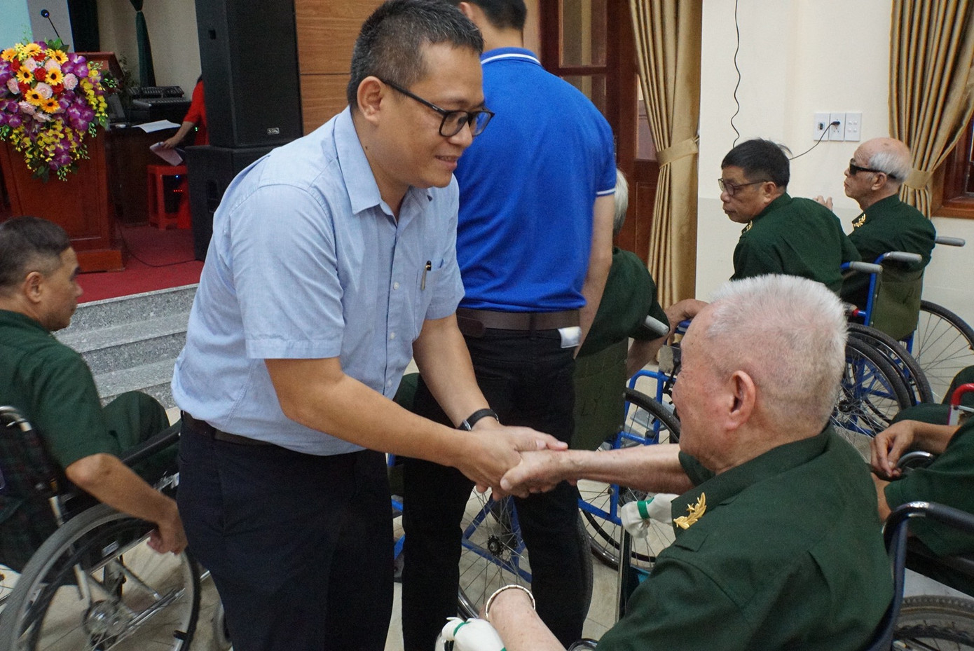 Đồng chí Hồ Sỹ Lực chúc sức khỏe một thương binh tại Trung tâm điều dưỡng thương bệnh binh nặng và người có công Duy Tiên (tỉnh Hà Nam).