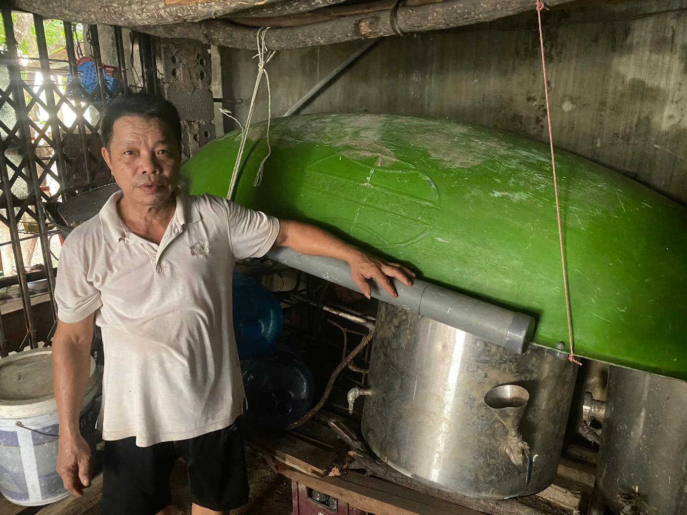 Ông Nguyễn Dương Tuấn bên cạnh con thuyền bằng nhựa của gia đình.