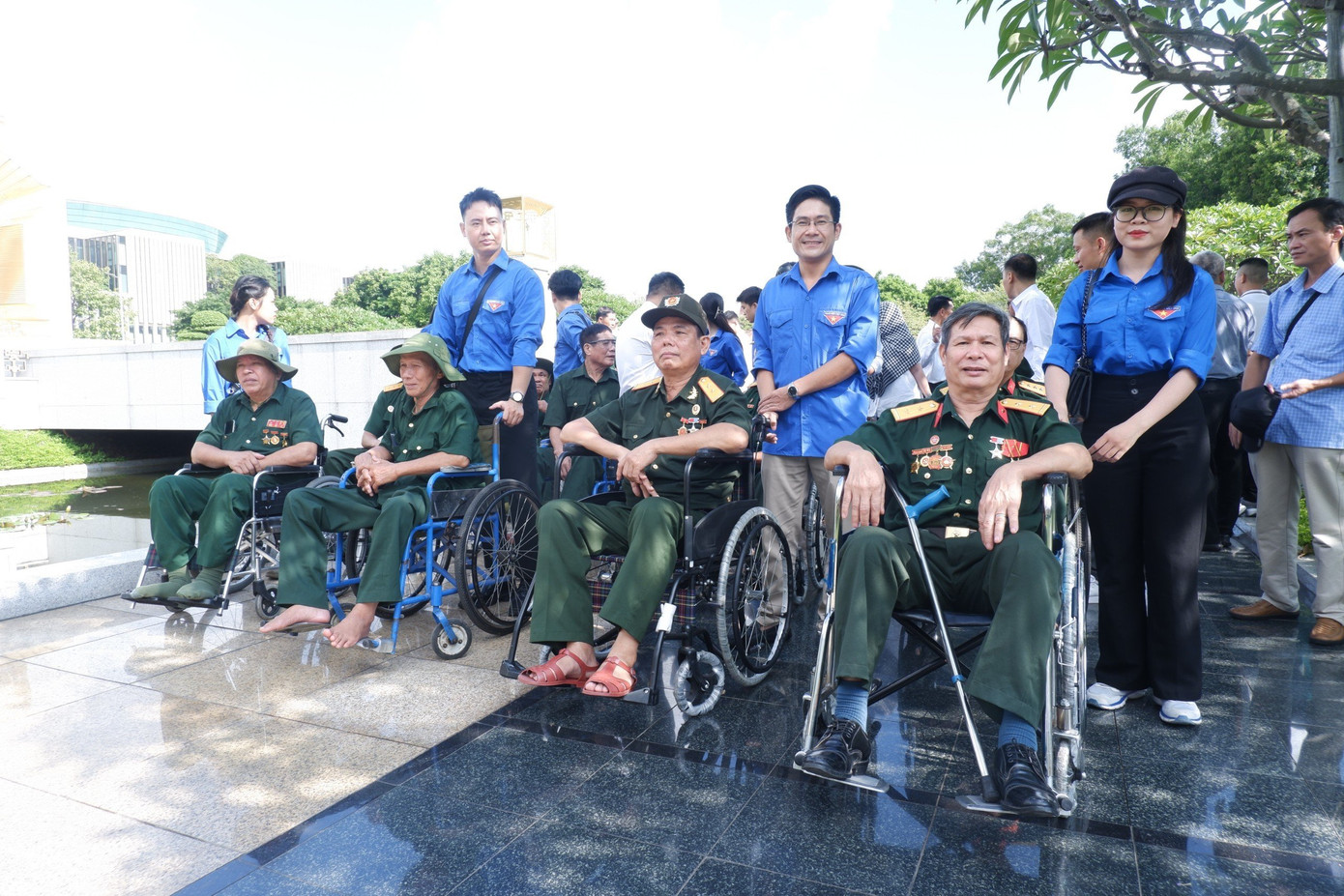 Các đoàn viên chụp hình lưu niệm với thương binh nặng tại khu vực Đài tưởng niệm các Anh hùng, liệt sĩ.