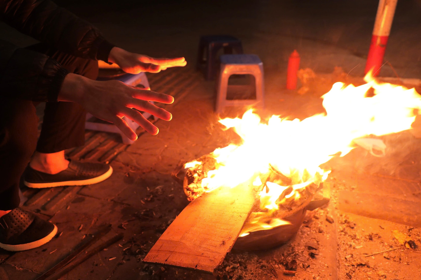 Một tiểu thương tranh thủ sưởi ấm.