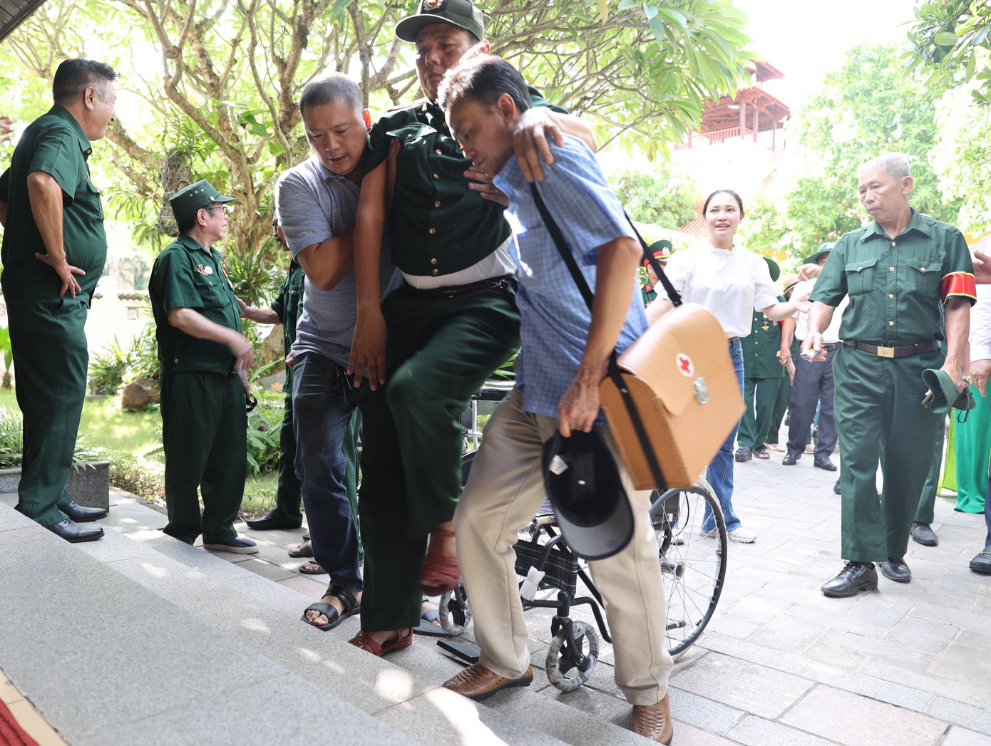 Thanh niên nhiều đơn vị cùng hỗ trợ những thương binh nặng di chuyển vào khu vực chiếu phim tài liệu về Chủ tịch Hồ Chí Minh.