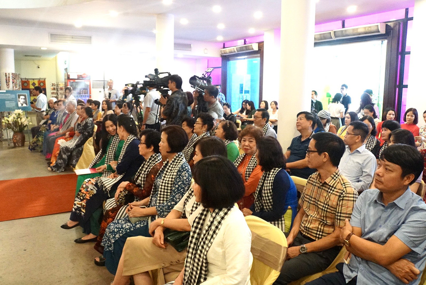 Quang cảnh buổi tiếp nhận bức tranh chân dung bà Nguyễn Thị Định làm từ lá sen. Nhiều đại biểu, khách mời đã quàng trên cổ chiếc khăn rằn - một hình ảnh đặc trưng luôn gắn liền với bà Nguyễn Thị Định.