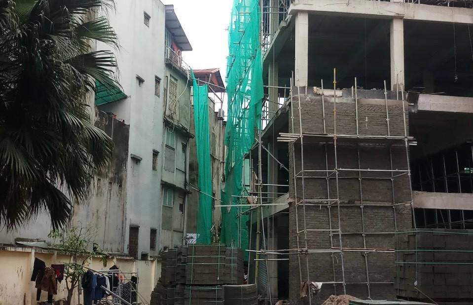 Hình ảnh chứng minh việc đơn vị thi công tự ý gắn giàn giáo sang nhà người dân và không che chắn cẩn thận công trình xây dựng.