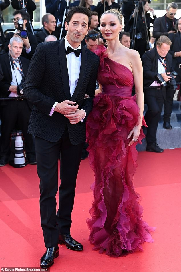 Diễn viên/nhà thiết kế thời trang Georgina Chapman lộng lẫy với váy lệch vai bằng vải tuyn xếp nếp. Hộ tống mỹ nhân 50 tuổi là chồng, tài tử Adrien Brody. Ảnh: Shutterstock/Getty Images.