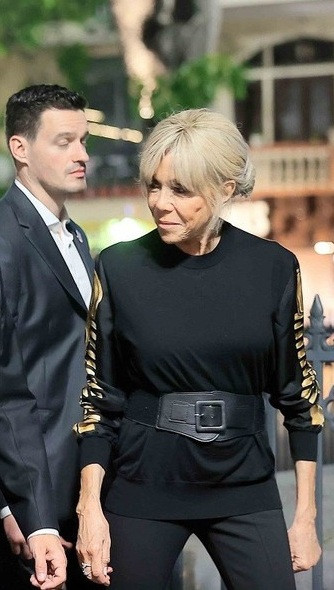 Khi dạo phố đi bộ Hồ Gươm vào tối 26/5, bà thể hiện sự cá tính và mạnh mẽ với áo dài tay đen, điểm vàng ở hai ống tay, quần dài ống loe và giày da đồng bộ. Điểm nhấn của cả set đồ là chiếc thắt lưng to bản bằng da. Ảnh: TTXVN