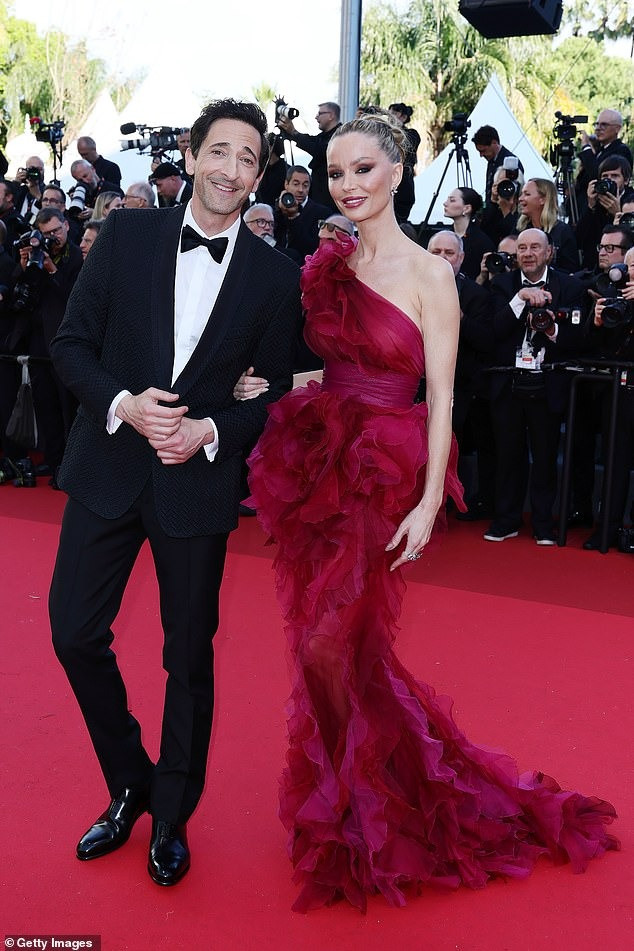 Diễn viên/nhà thiết kế thời trang Georgina Chapman lộng lẫy với váy lệch vai bằng vải tuyn xếp nếp. Hộ tống mỹ nhân 50 tuổi là chồng, tài tử Adrien Brody. Ảnh: Shutterstock/Getty Images.