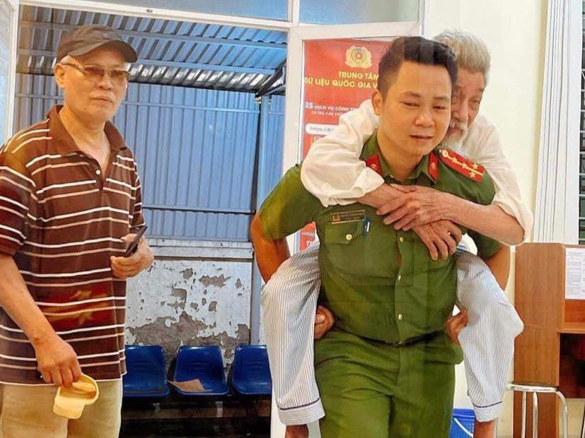 Cán bộ, chiến sĩ hỗ trợ người già làm thủ tục.