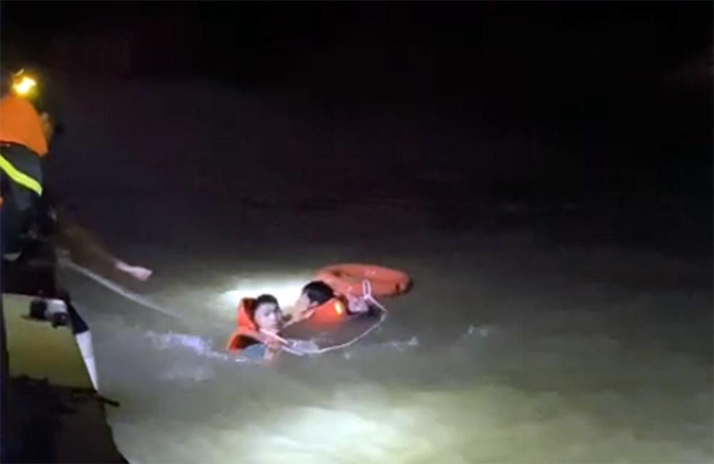 Lực lượng chức năng đưa nạn nhân lên ca nô cứu hộ.