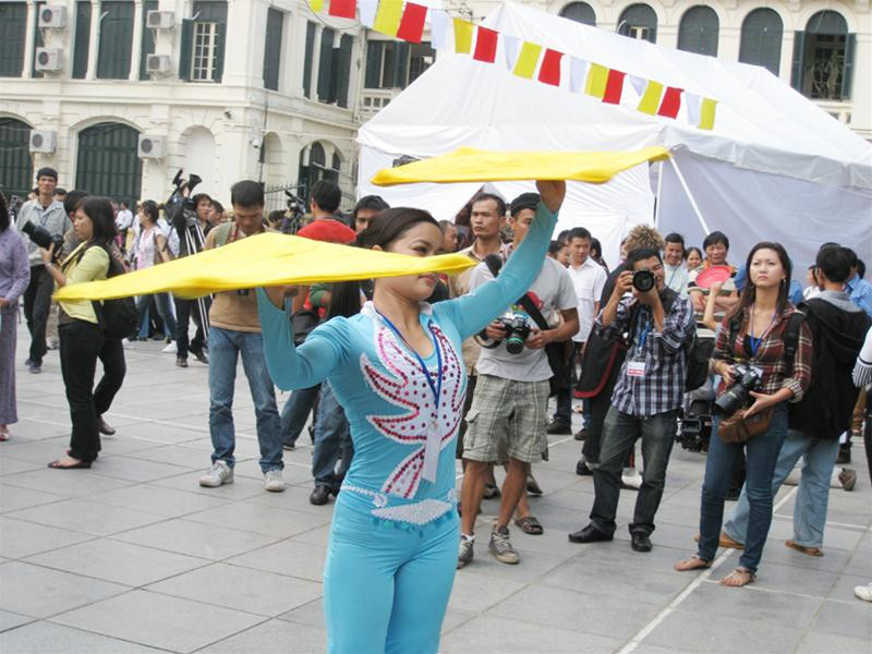 Một nghệ nhân làm xiếc với hai miếng vải màu vàng trên tay. Một nghệ nhân làm xiếc với hai miếng vải màu vàng trên tay.