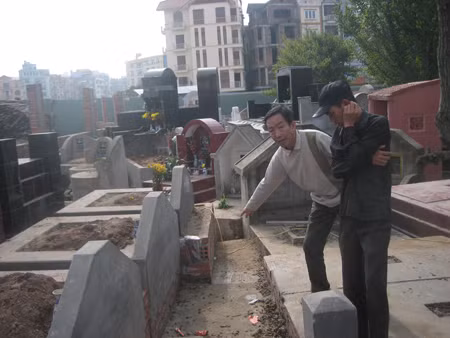 Dũng “mồ mả” (trái) đang bàn thảo giá một huyệt mộ với khách