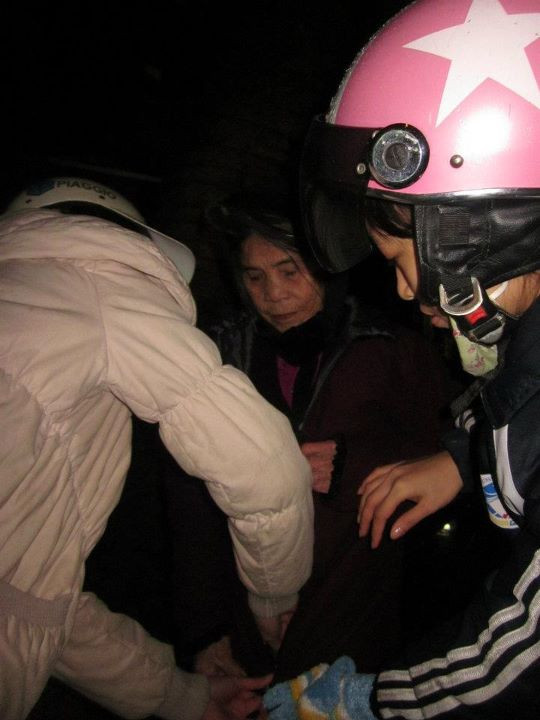 Các bạn tình nguyện viên mặc áo ấm cho người được tặng