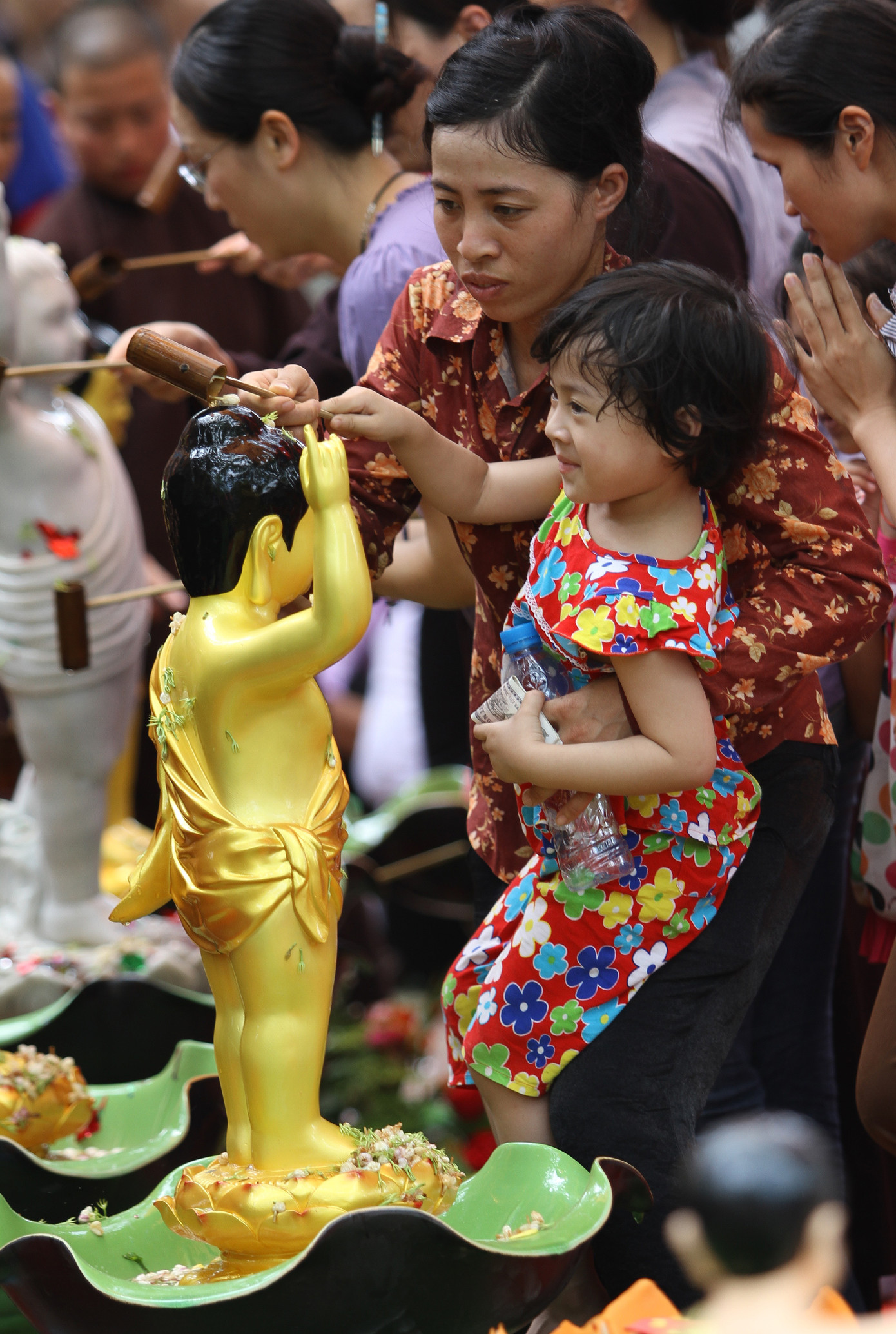 Có cả các bé ở tuổi chưa biết tự tắm được bố mẹ đưa tới để dự lễ