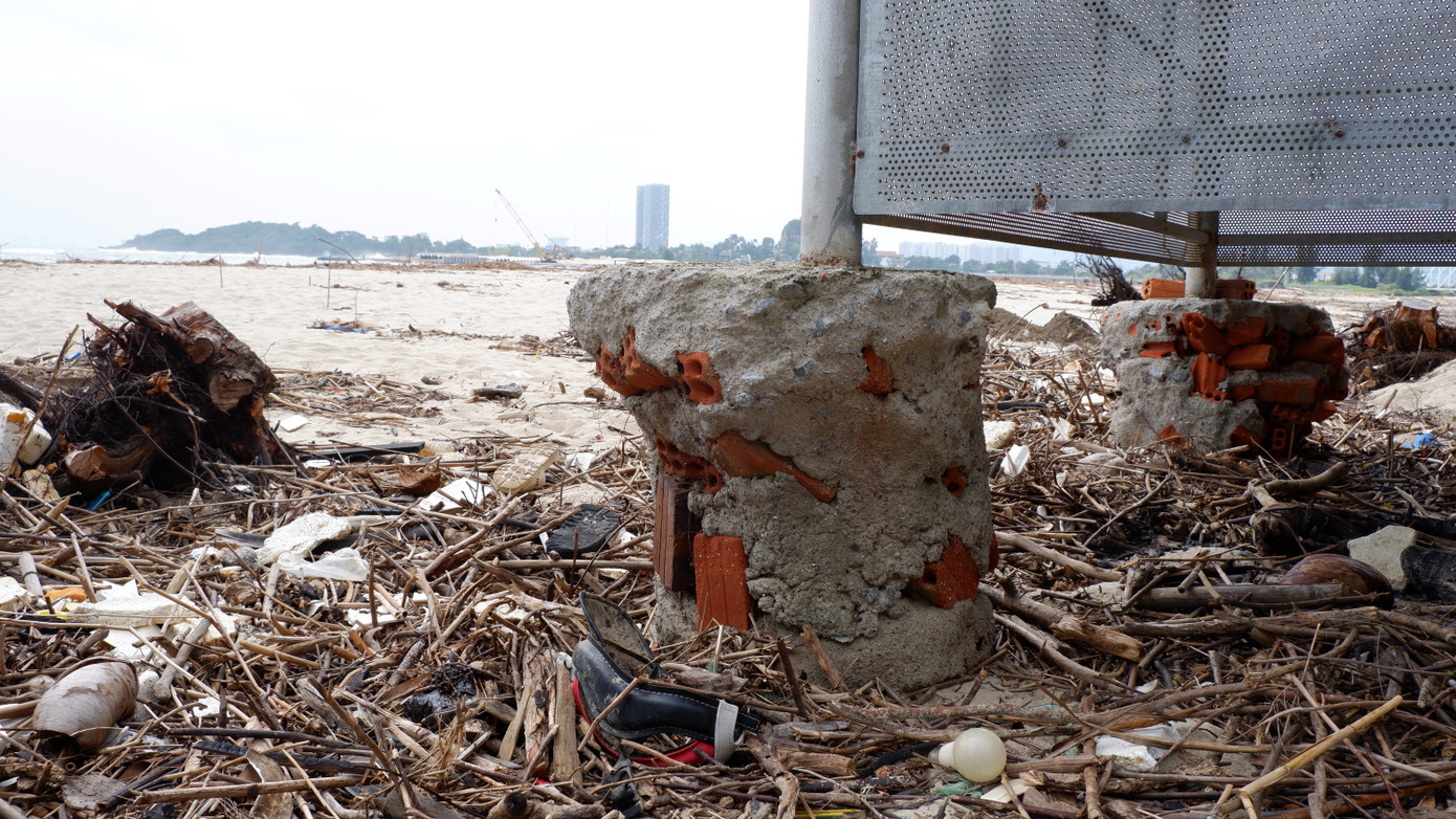 Xói lở, xâm thực ăn sâu vào nền móng một công trình tại bãi biển đoạn gần cầu Nam Ô, đối diện là dự án khu du lịch sinh thái Nam Ô đang thi công. Ảnh: Nguyễn Thành