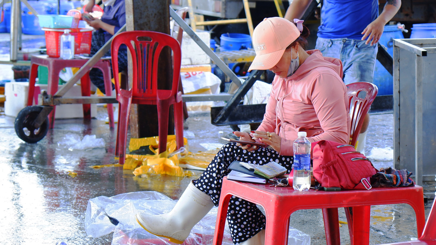 Tiểu thương, chủ tàu thu tiền bán hải sản ngay tại chợ cảng cá Thọ Quang. (Ảnh: Nguyễn Thành)