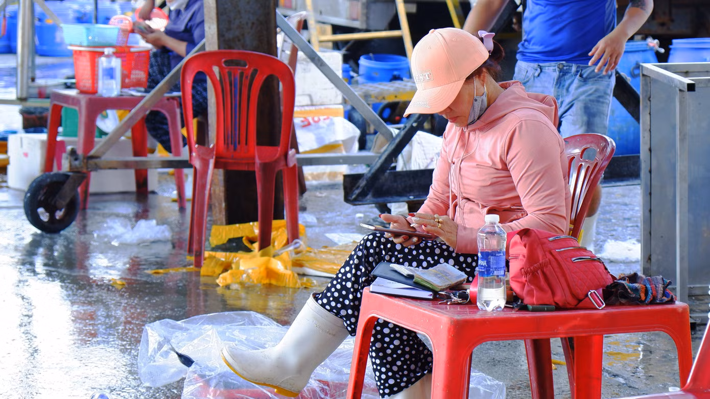 Tiểu thương, chủ tàu thu tiền bán hải sản ngay tại chợ cảng cá Thọ Quang. (Ảnh: Nguyễn Thành)
