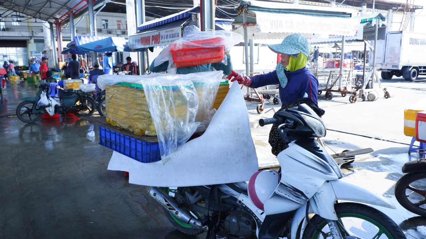 Tiểu thương các chợ sau khi chọn và mua được hải sản chất lên xe máy để đưa về chợ bán. (Ảnh: Nguyễn Thành)