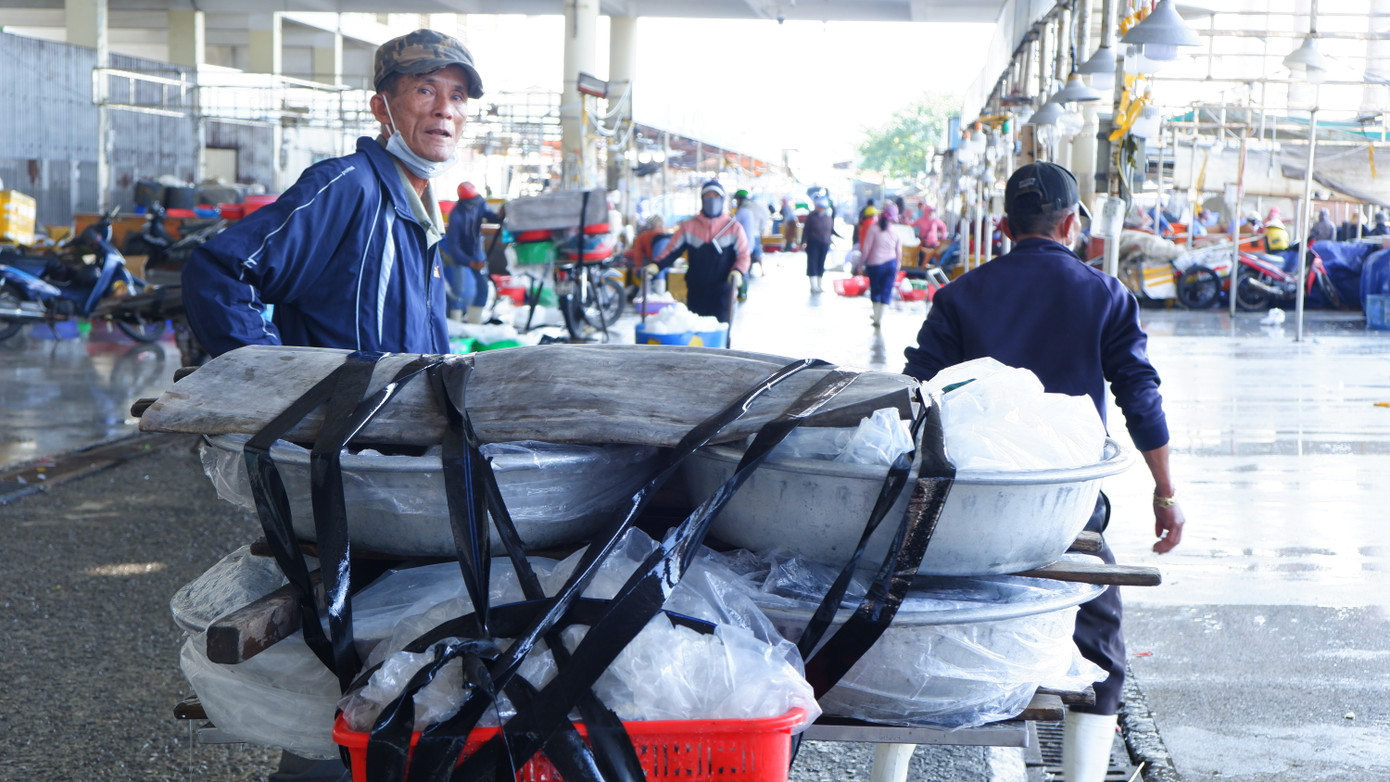 Tiểu thương các chợ sau khi chọn và mua được hải sản chất lên xe máy để đưa về chợ bán. (Ảnh: Nguyễn Thành)