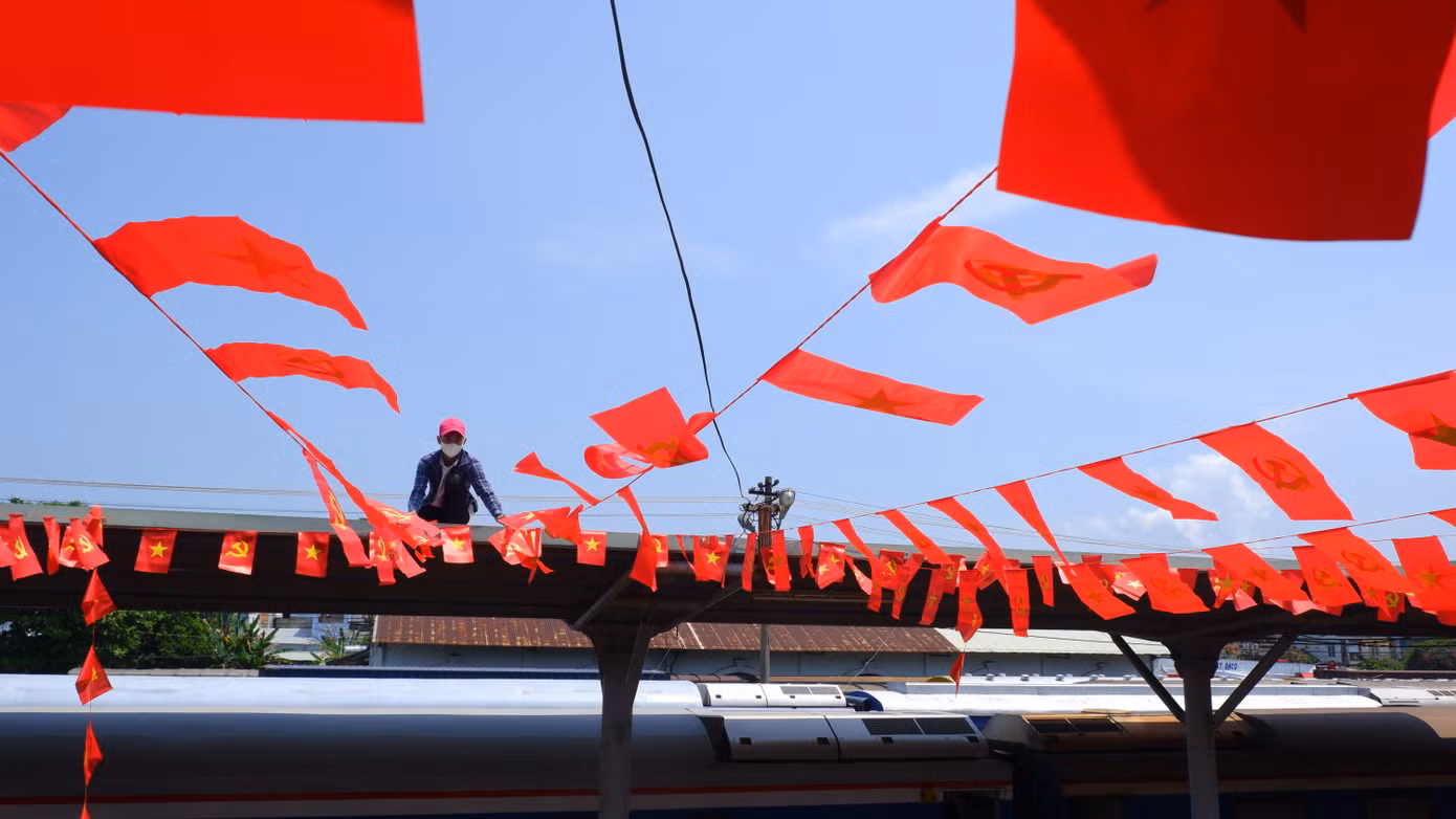 Công nhân trang trí cờ bên trong ga Đà Nẵng.