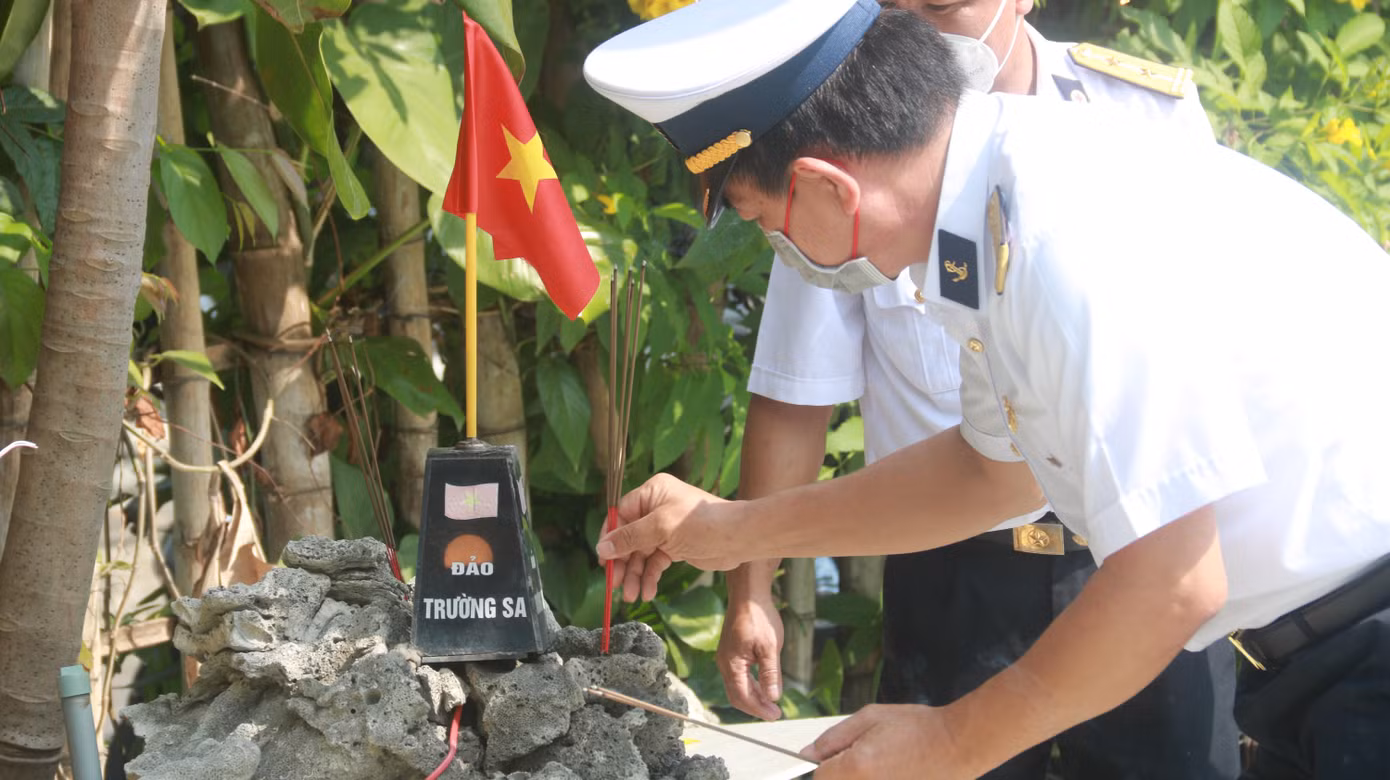 Thắp nén hương tưởng nhớ đồng đội cạnh mô hình quần đảo Trường Sa trong khuôn viên rợp cây xanh ở nơi làm lễ tưởng niệm.