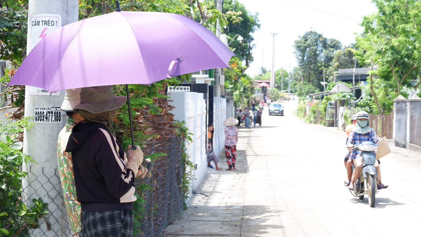 Người dân che ô chờ đón linh cữu nguyên Chủ tịch nước Trần Đức Lương.