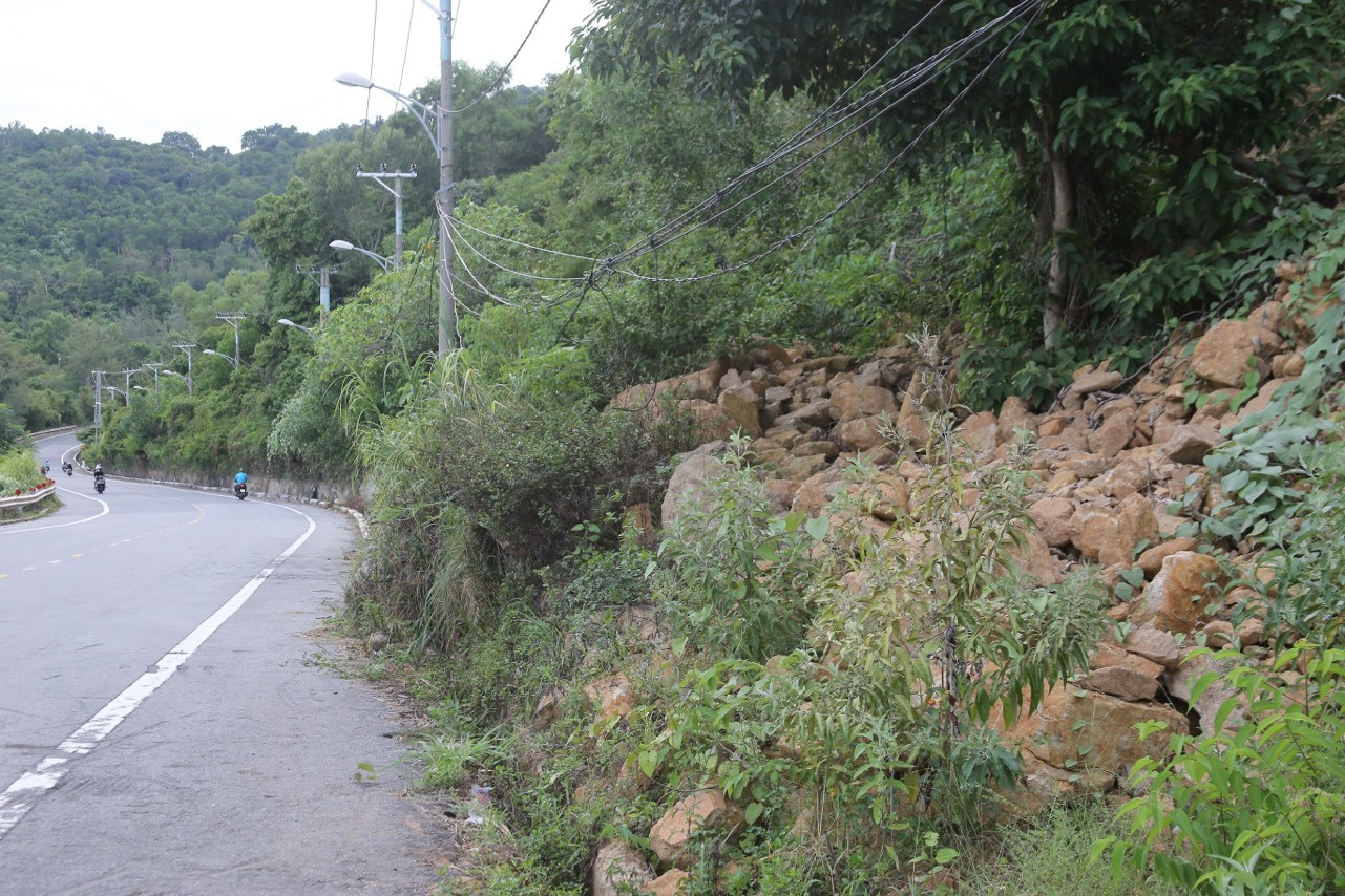 Đất đá từ trên núi lăn xuống nằm sát mép đường.