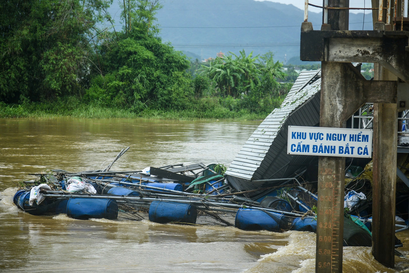 Lồng bè nuôi cá, các tấm tôn mắc kẹt tại cửa đập khiến mực nước thượng nguồn dâng cao, gây mất an toàn đập. Lồng bè nuôi cá, các tấm tôn mắc kẹt tại cửa đập khiến mực nước thượng nguồn dâng cao, gây mất an toàn đập.