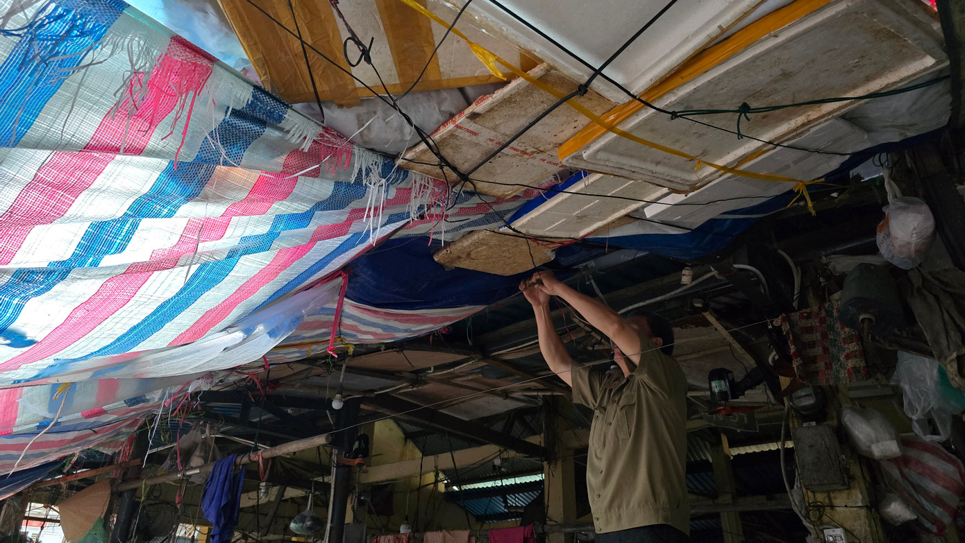 Tiểu thương chợ Mai chằng níu che chắn các rạp bán bên trong chợ sau trận bão số 6 (Trà Mi).