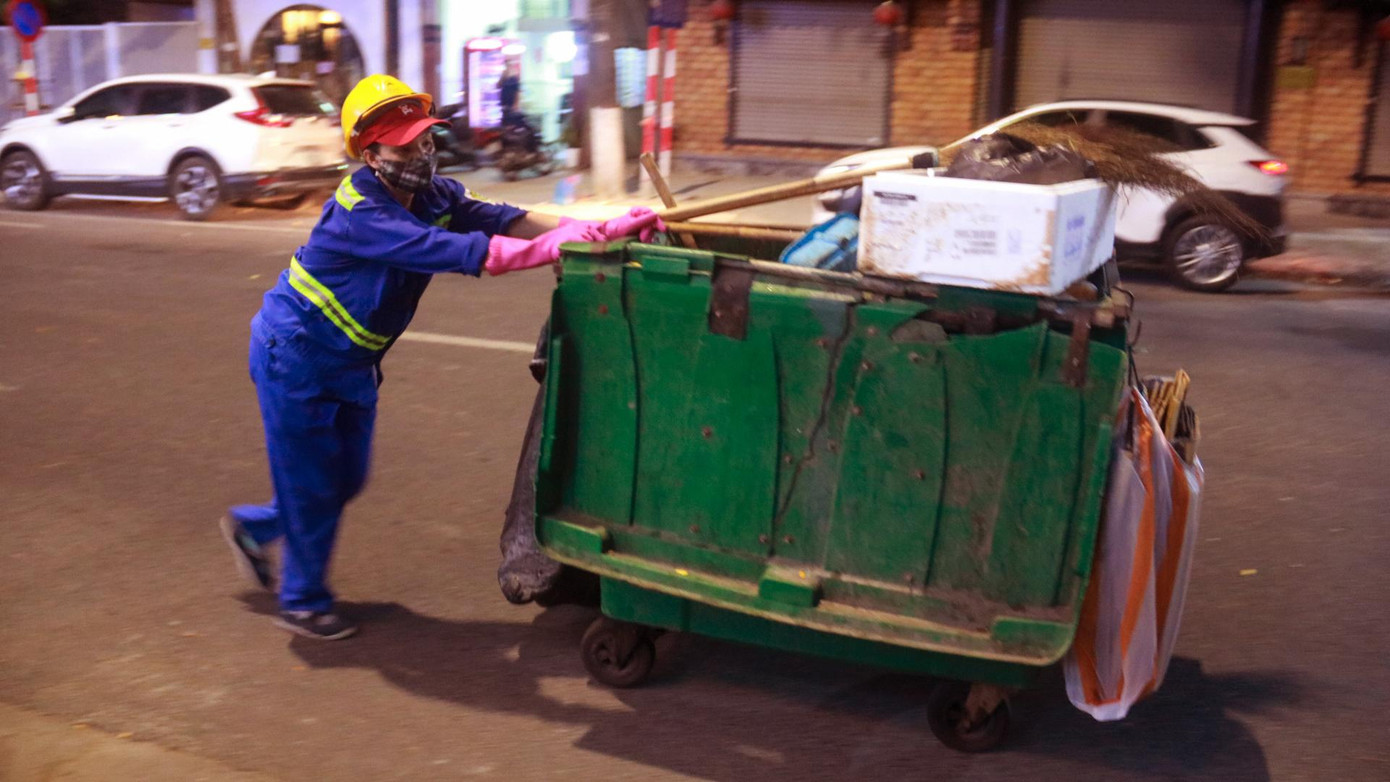 Nữ lao công quét rác vẫn âm thầm làm việc giữa phố phường vắng lặng không bóng người. Nữ lao công quét rác vẫn âm thầm làm việc giữa phố phường vắng lặng không bóng người.