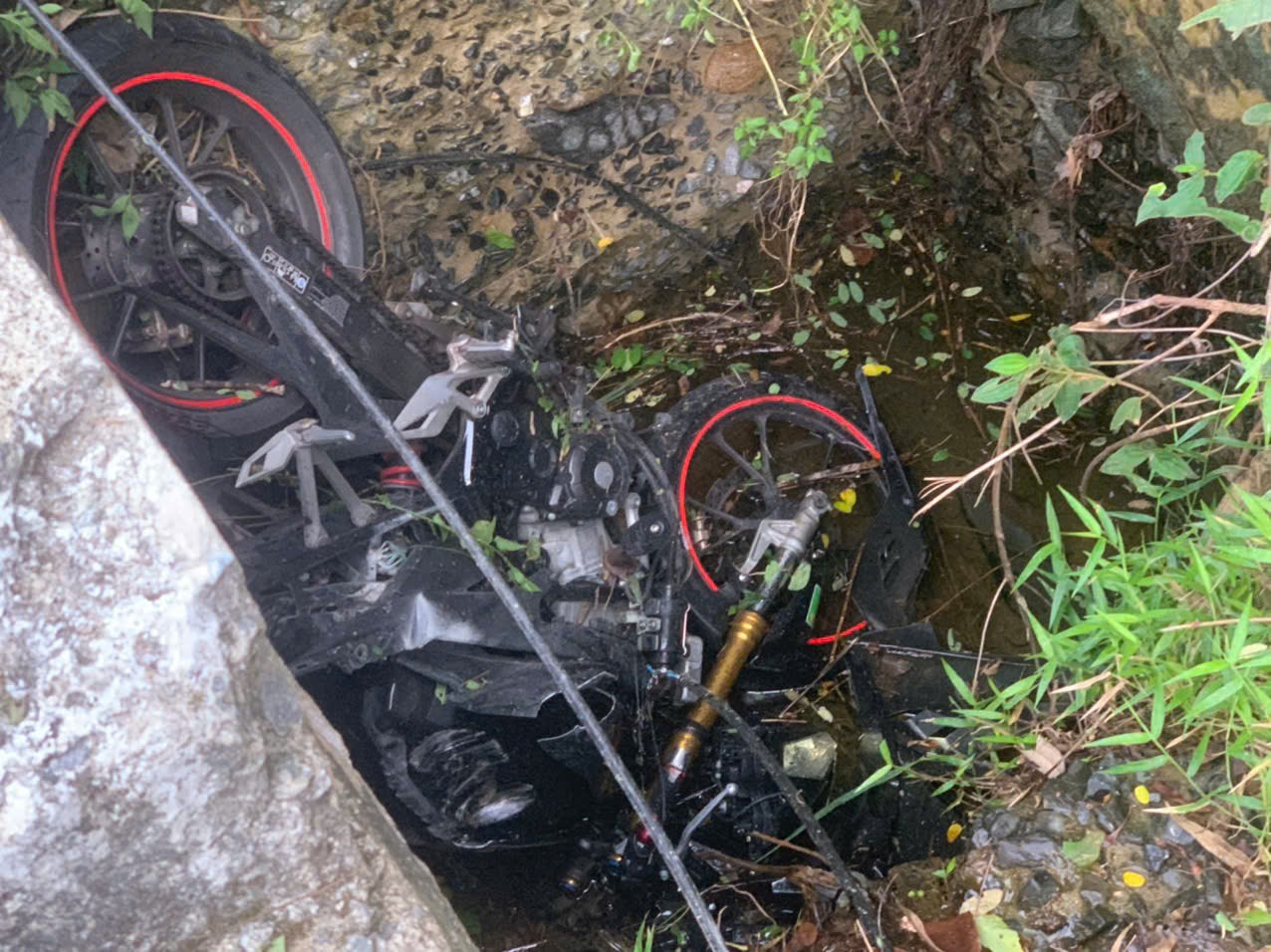 Xe máy nát bét nằm dưới mương thoát nước.