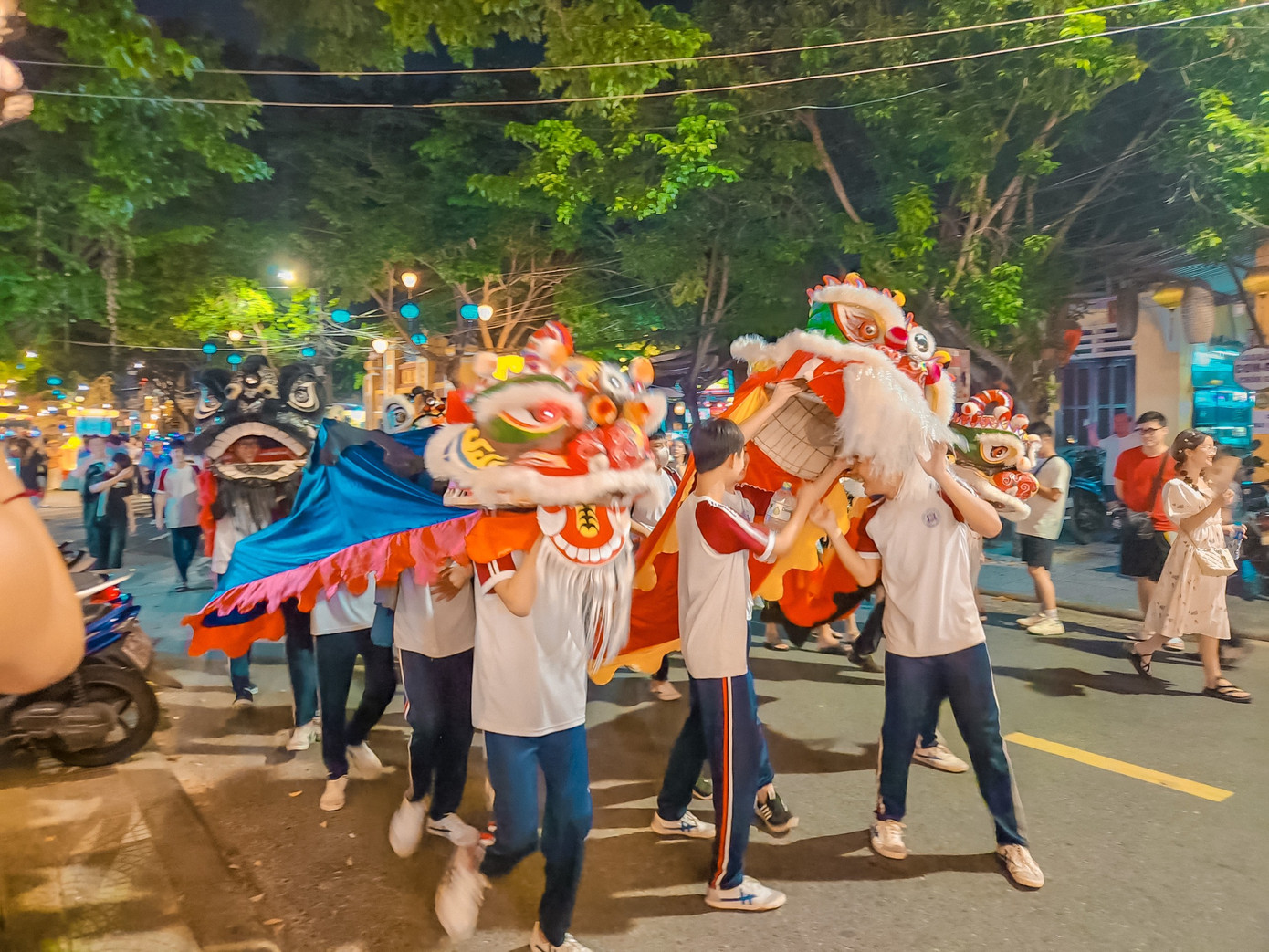 Một đội lân trên đường phố Hội An chuẩn bị biểu diễn phục vụ du khách và người dân.