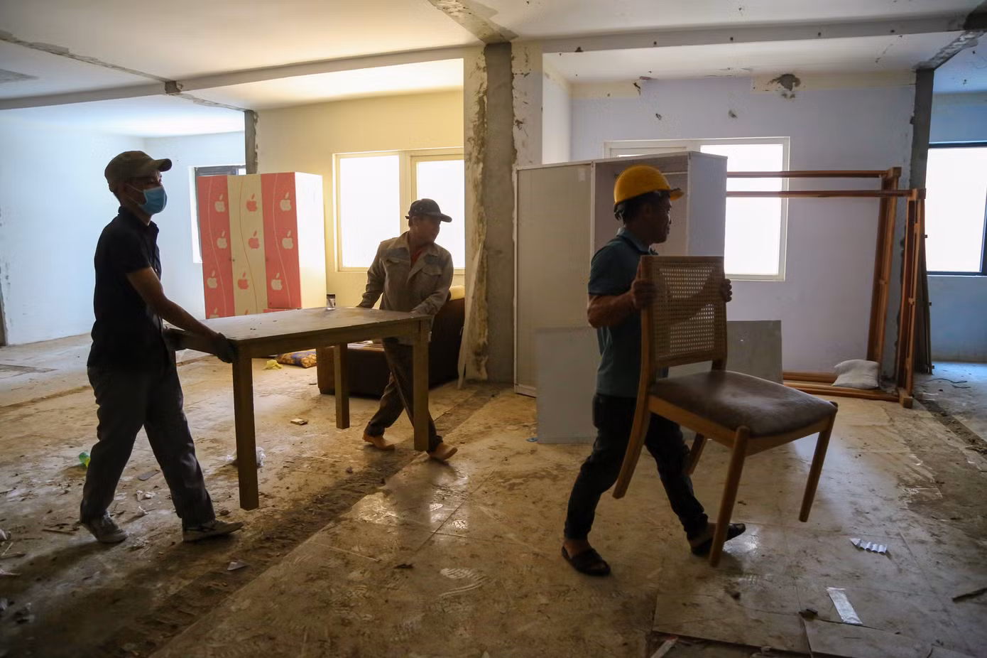 Công nhân di dời các vật dụng bên trong căn hộ để phục vụ việc tháo dỡ.