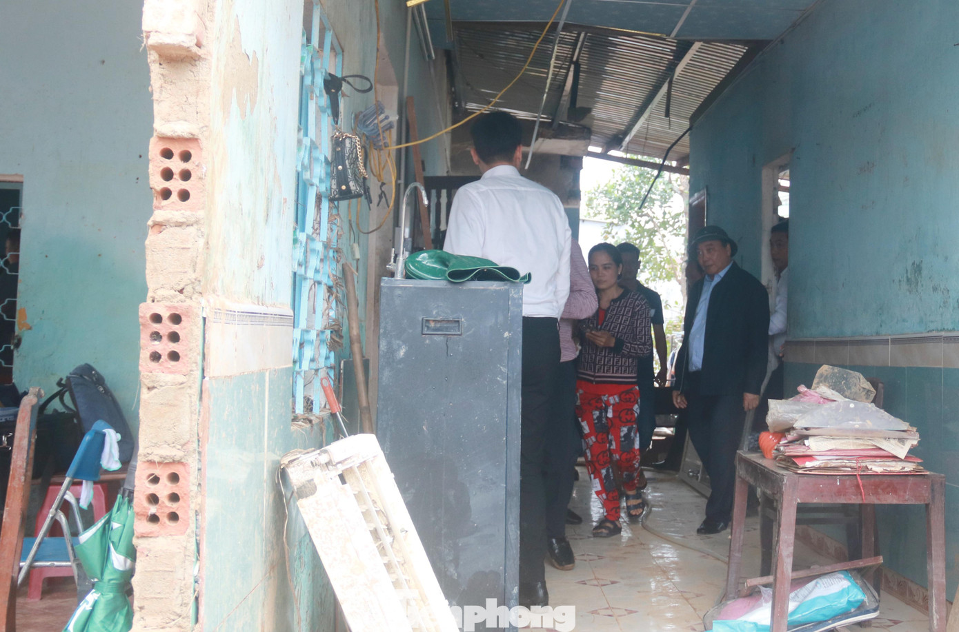 Chủ tịch nước trực tiếp vào bên trong ngôi nhà không còn nguyên vẹn của gia đình bà Hoa để kiểm tra, ghi nhận thiệt hại và chỉ đạo lực lượng chức năng, chính quyền sớm giúp gia đình sửa sang lại nhà cửa hư hỏng. Ảnh: Nguyễn Thành