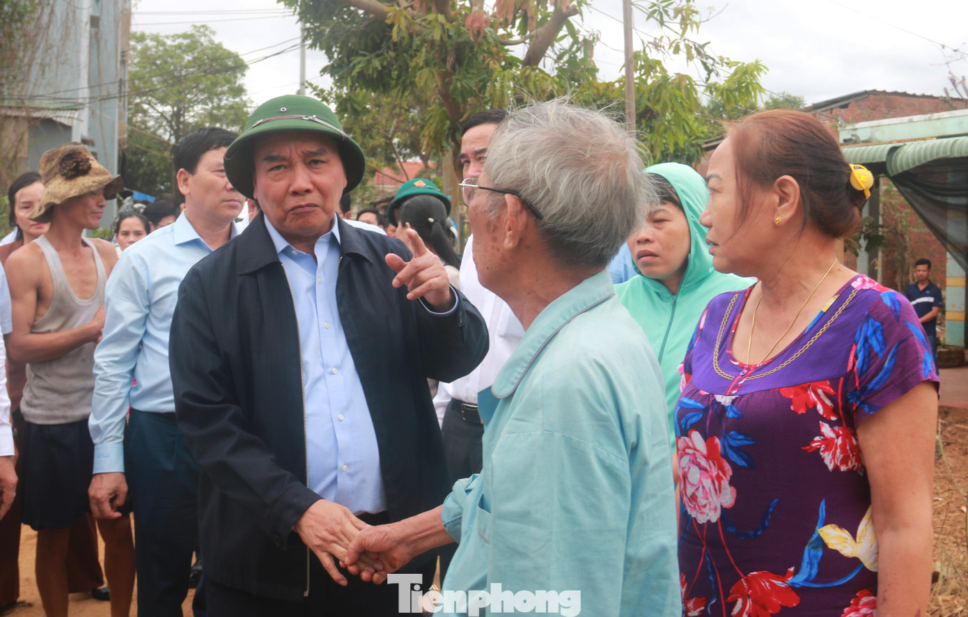 Chủ tịch nước ân cần thăm hỏi, động viên tinh thần người dân thôn Thạch Nham Đông bị thiệt hại do mưa lũ. Ảnh: Nguyễn Thành