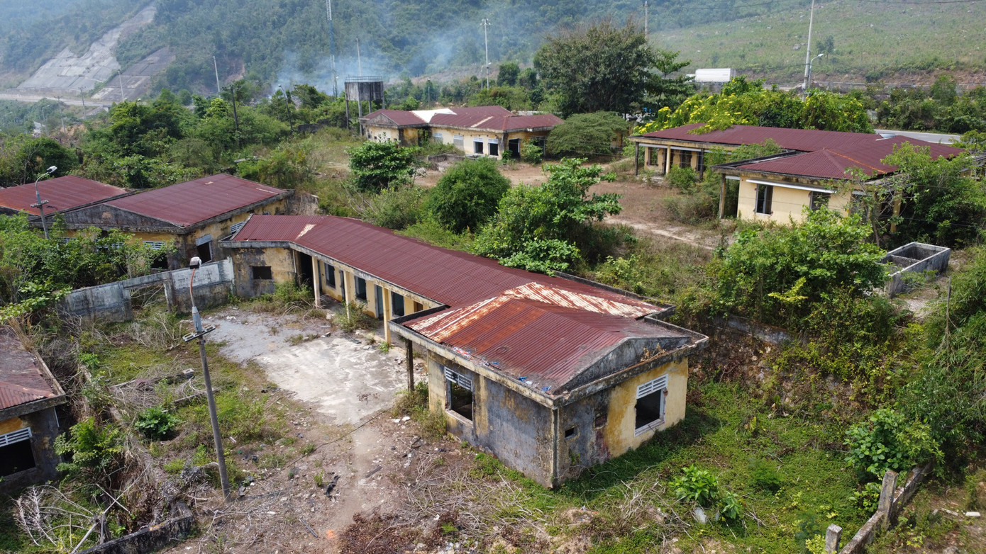 Một góc khu đất với các dãy nhà chức năng bỏ hoang cây cối, cỏ dại mọc thành rừng.