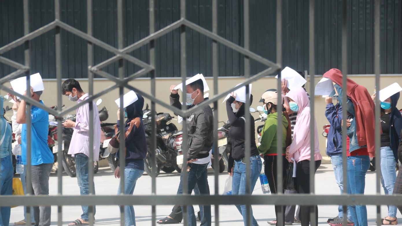 Các công nhân tại khu công nghiệp Hòa Khánh (quận Liên Chiểu) đổi ca xếp hàng để xét nghiệm và tiêm vắc xin phòng COVID-19.