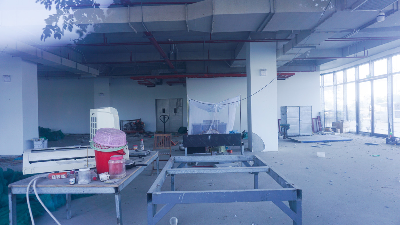 Một góc bên trong tầng 1 của công trình ngổn ngang các vật dụng, sắt thép.