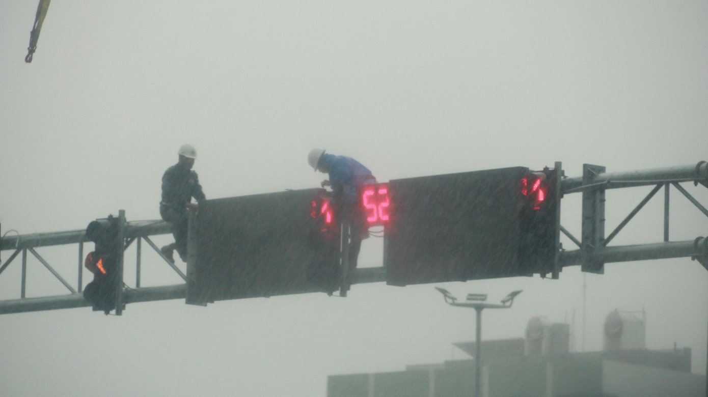 Lực lượng chức năng tháo dỡ các biển chỉ dẫn tại một nút giao thông trên tuyến đường Ngô Quyền (quận Sơn Trà) để đảm bảo an toàn khi bão đổ bộ vào.