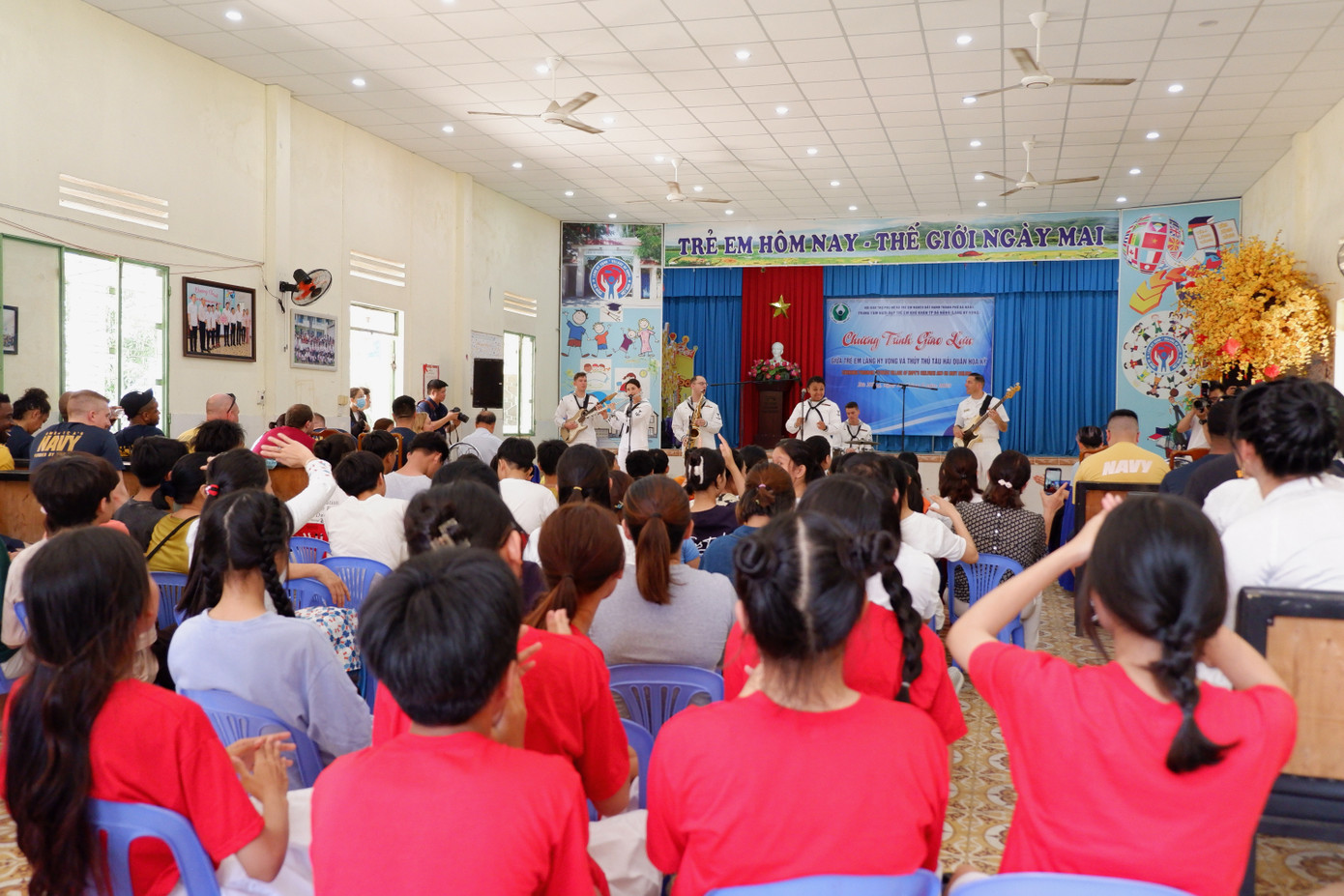 Các em nhỏ mồ côi tại Làng Hy vọng say sưa nghe ban nhạc Hải quân Mỹ biểu diễn hàng loạt ca khúc tiếng Anh vui nhộn. Ảnh: Nguyễn Thành.