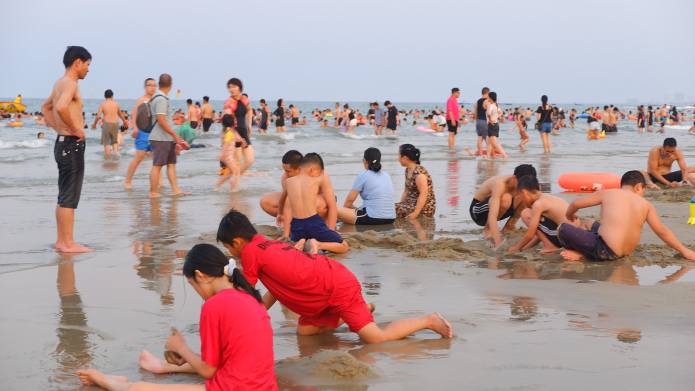 Trẻ nhỏ thích thú vui đùa trên bãi cát mịn, sạch.