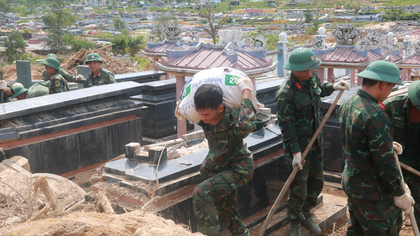 Chiến sĩ trẻ còng lưng vác đất đá ra khỏi khu vực sạt lở giúp người dân. Chiến sĩ trẻ còng lưng vác đất đá ra khỏi khu vực sạt lở giúp người dân.