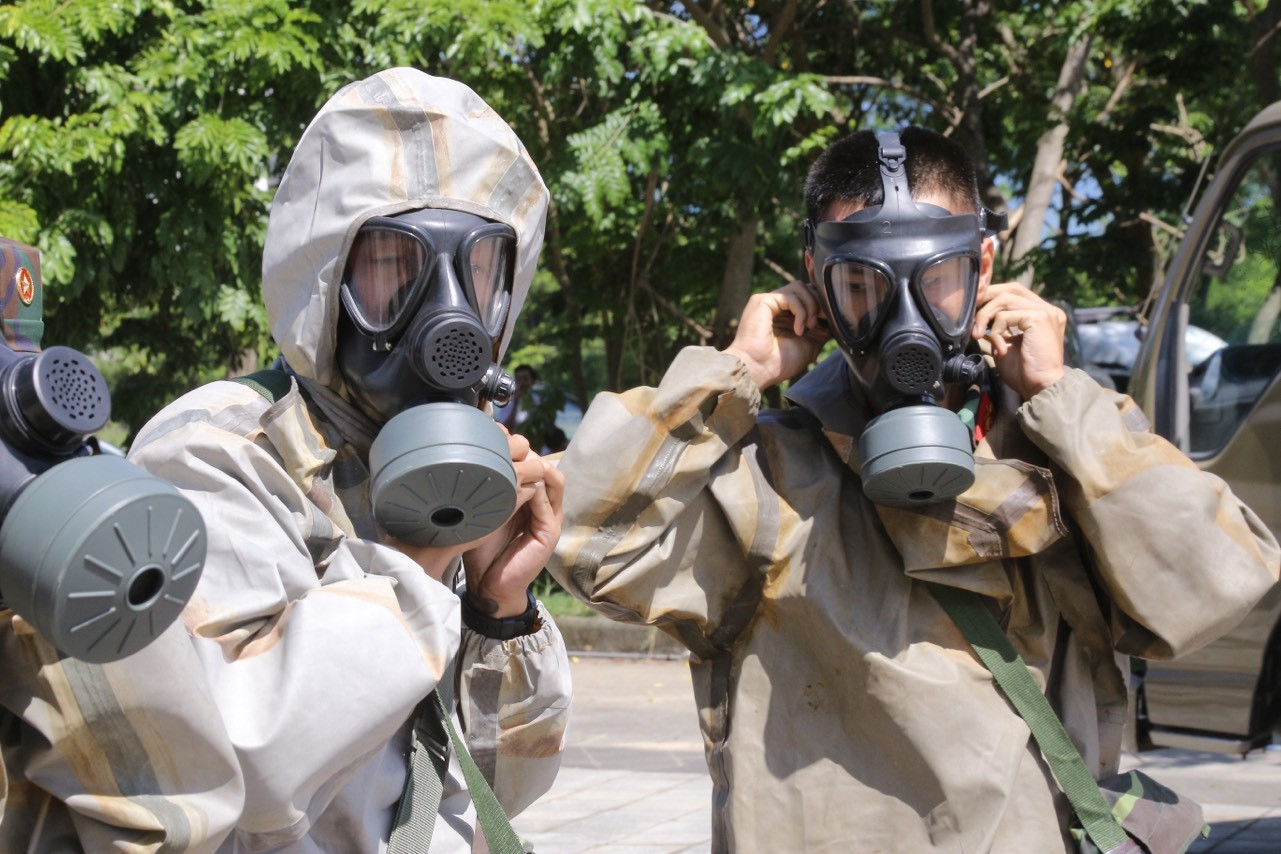 Lực lượng tẩy xạ của Bộ chỉ huy Quân sự thành phố trong bộ đồ chuyên dụng chuẩn bị tiến vào khu vực nhiễm phóng xạ và tiến hành tẩy xạ khi có hiệu lệnh.