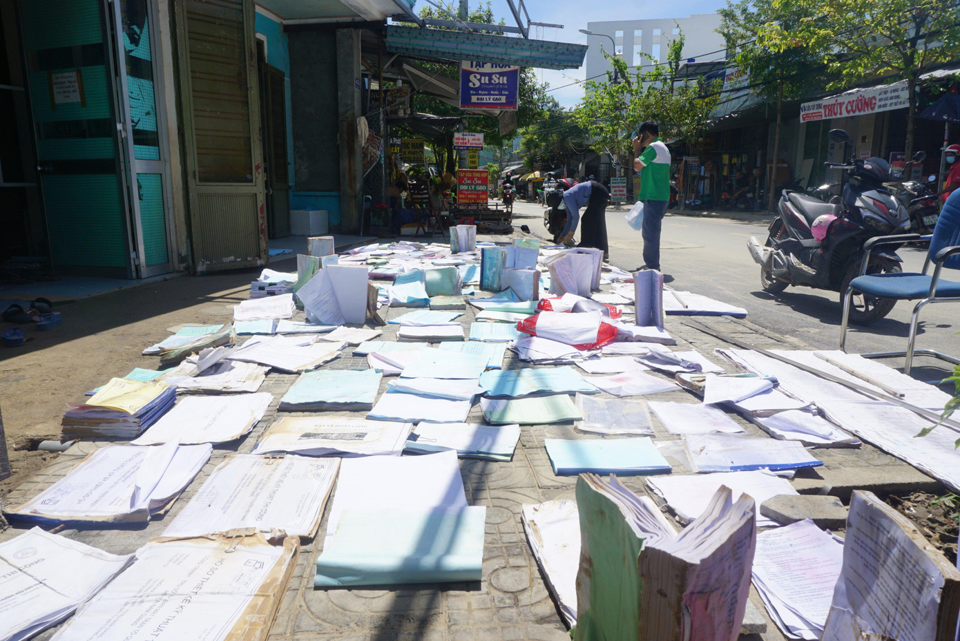 Tranh thủ trời nắng, người dân mang sách vở, giấy tờ bị ngập nước ra phơi.